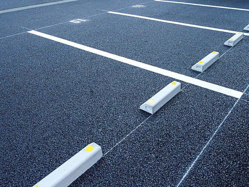 New striping and curb stops on a freshly maintained lot