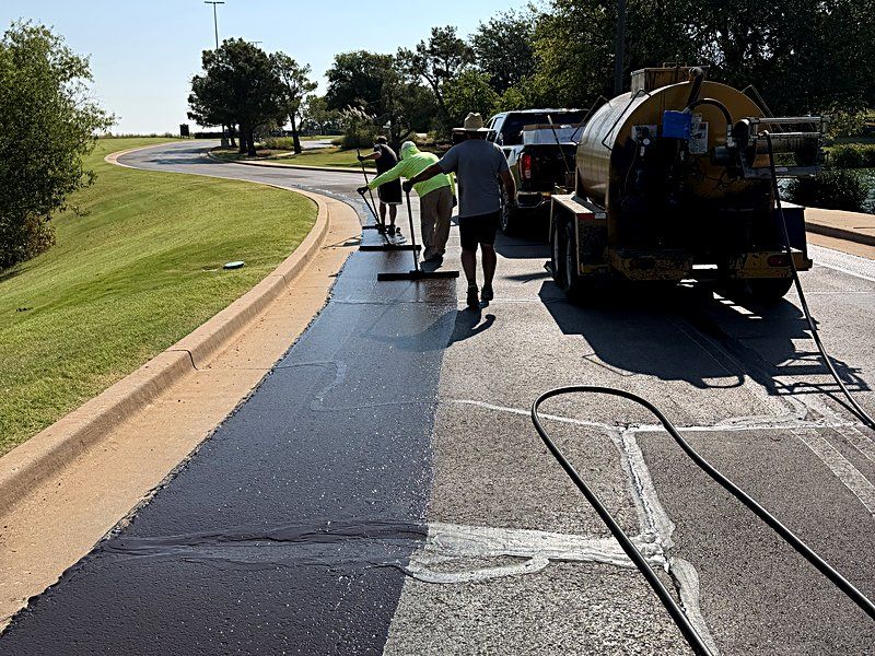 Heartland crew squeegeeing fresh sealcoat along a commercial drive