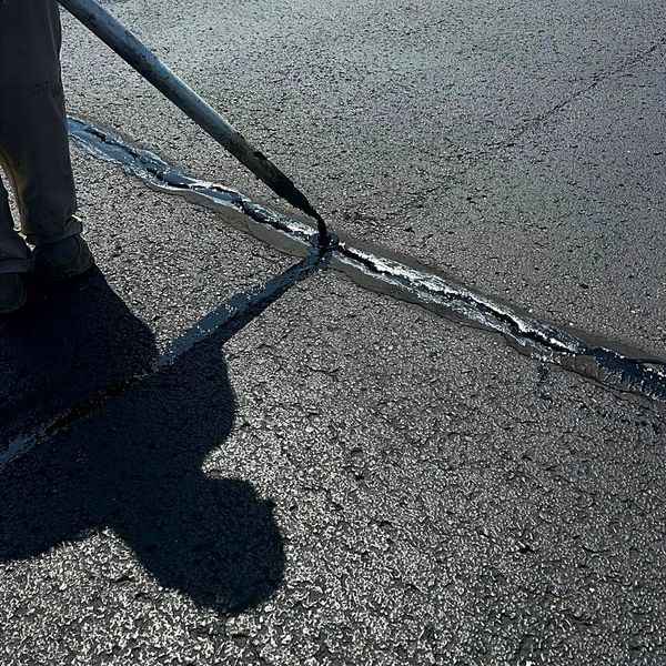 Rubberized crack sealant protecting asphalt from water damage