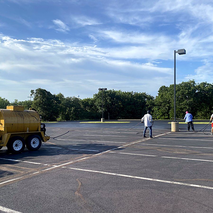 Heartland crew sealcoating a large commercial parking lot in the OKC metro