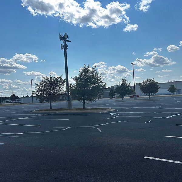 Freshly sealcoated and striped commercial lot under a big Oklahoma sky
